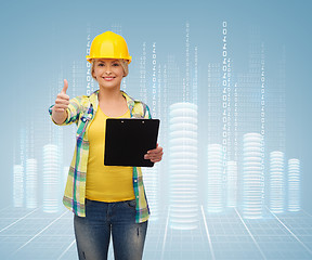 Image showing smiling woman in helmet with clipboard