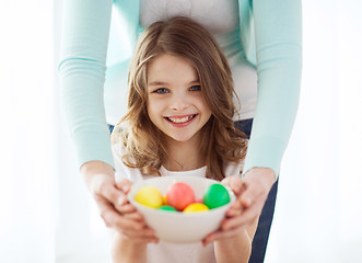 Image showing smiling girl and mother holding colored eggs