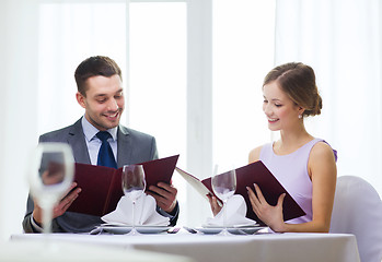 Image showing smiling couple with menus at restaurant