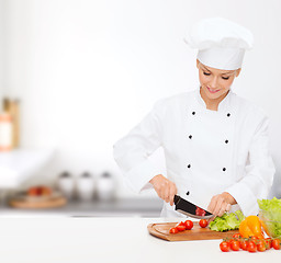 Image showing smiling female chef chopping vagetables