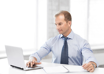 Image showing miling businessman working in office