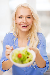 Image showing smiling young woman with green salad at home