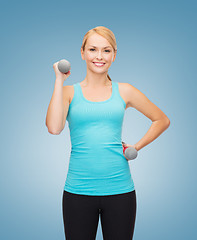 Image showing young sporty woman with light dumbbells