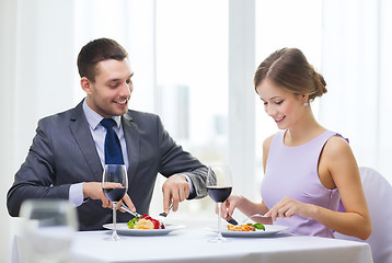 Image showing smiling couple eating main course at restaurant