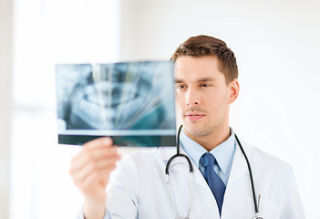 Image showing concerned male doctor or dentist looking at x-ray