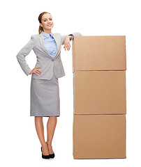 Image showing smiling businesswoman with cardboard boxes