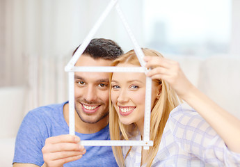 Image showing smiling couple with house from measuring tape