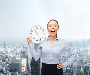 Image showing attractive businesswoman with wall clock