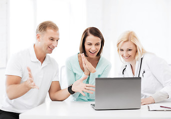 Image showing doctor with patients looking at laptop