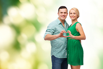 Image showing smiling couple showing heart with hands