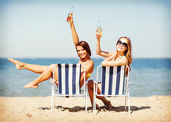 Image showing girls sunbathing on the beach chairs