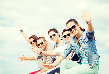 Image showing group of teenagers waving hands