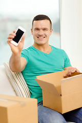 Image showing opening cardboard box and taking out smartphone