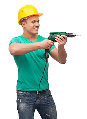 Image showing smiling manual worker in helmet with drill machine