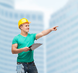 Image showing smiling man in helmet with clipboard