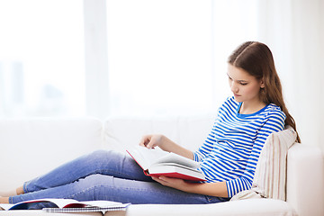 Image showing calm teenage girl reading book on couch