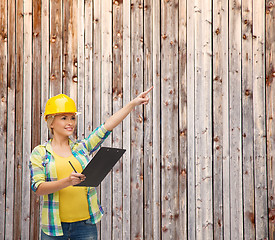 Image showing smiling woman in helmet with clipboard