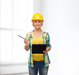 Image showing smiling woman in helmet with clipboard