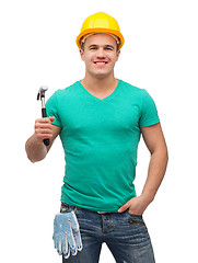 Image showing smiling manual worker in helmet with hammer