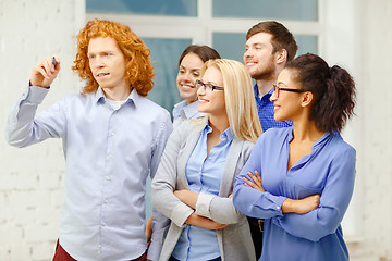 Image showing smiling creative team writing on virtual screen