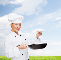 Image showing smiling female chef with pan and spoon