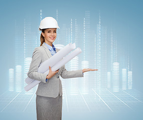 Image showing smiling architect in white helmet with blueprints