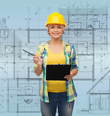 Image showing smiling woman in helmet with clipboard