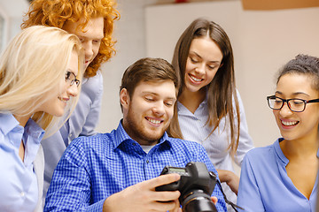 Image showing smiling team with photocamera in office