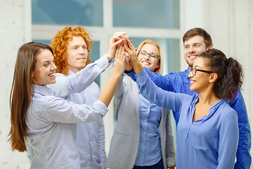 Image showing creative team doing high five gesture in office