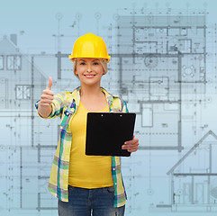 Image showing smiling woman in helmet with clipboard