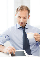 Image showing businessman with tablet pc and coffee in office