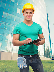 Image showing smiling man in helmet with clipboard