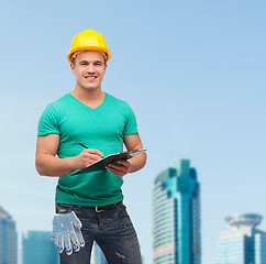 Image showing smiling man in helmet with clipboard