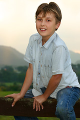 Image showing Child sitting on fence