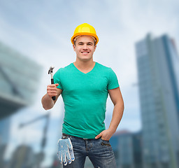 Image showing smiling manual worker in helmet with hammer