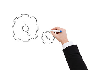 Image showing close up of businessman drawing cogwheel