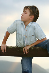 Image showing Boy climbing on a fence