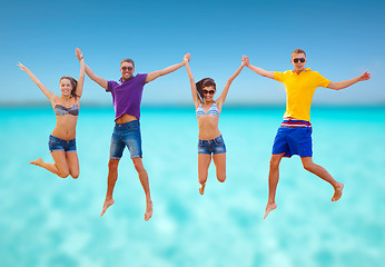 Image showing group of friends or couples jumping on the beach