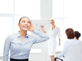 Image showing smiling businesswoman listening gossig