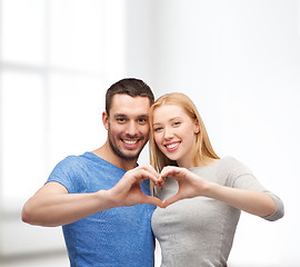 Image showing smiling couple showing heart with hands