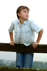 Image showing Child leaning on a fence