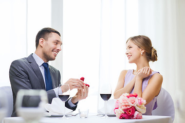 Image showing man proposing to his girlfriend at restaurant