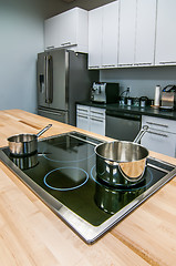 Image showing kitchen butcher table island with stove top and pans