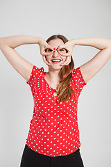 Image showing Smiling attractive woman through finger goggles