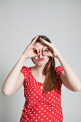 Image showing Attractive woman looking through finger goggles