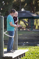 Image showing Cute Young Boy and Dad Fishing on the Lake Dock