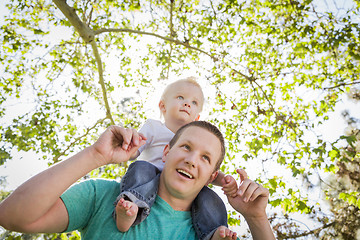 Image showing Cute Young Boy Rides Piggyback On His Dads Shoulders