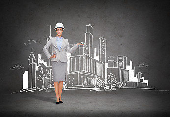 Image showing businesswoman in helmet showing town drawing