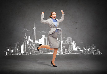 Image showing happy woman jumping with hands up