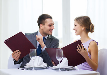 Image showing smiling couple with menus at restaurant